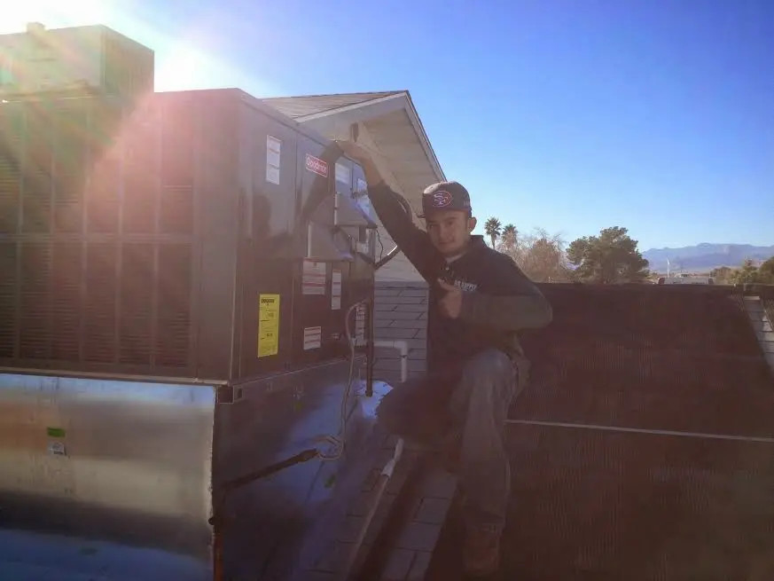 HVAC technician performing Air Duct Cleaning on a rooftop unit in Bull Run